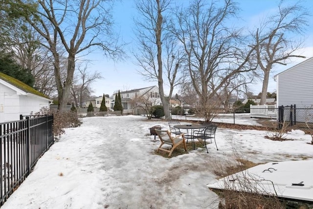 yard layered in snow with a residential view and a fenced backyard