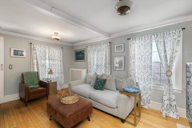 living area with hardwood / wood-style flooring, beamed ceiling, crown molding, and baseboards