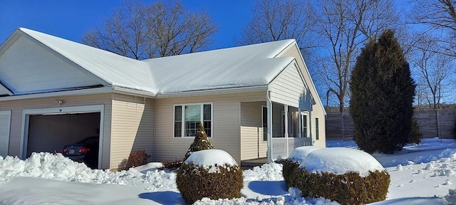 snow covered property featuring a garage