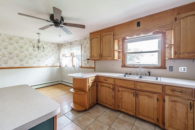 46 Birchland Ave, Springfield, MA 01119 - kitchen with wallpapered walls, light countertops, a peninsula, plenty of natural light, and a baseboard radiator