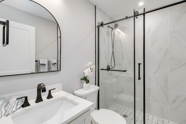 bathroom with vanity, a shower with shower door, and toilet