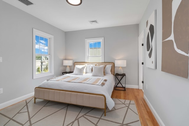 bedroom with multiple windows and wood-type flooring