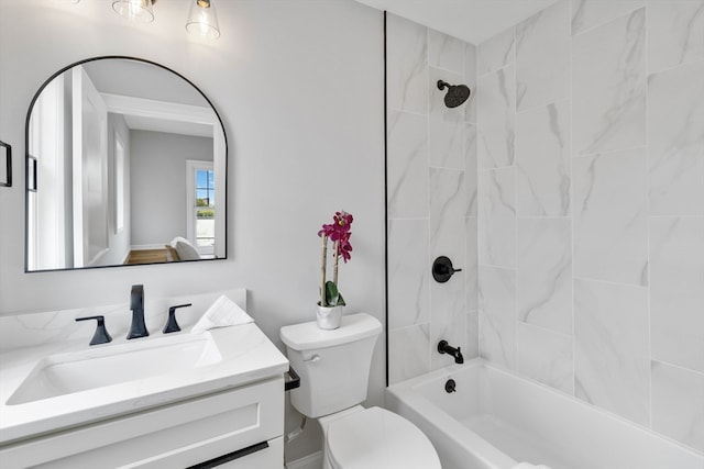 full bathroom featuring tiled shower / bath, vanity, and toilet