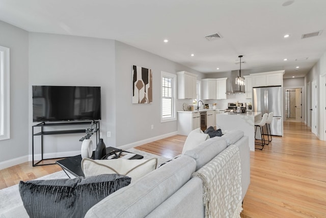 living room featuring sink and light hardwood / wood-style flooring