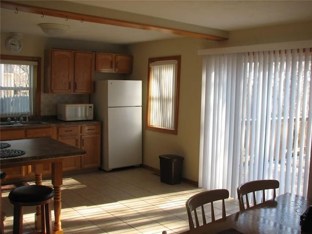 436 Brown St, Attleboro, MA 02703 - kitchen featuring white appliances, a sink, tasteful backsplash, beamed ceiling, and light tile patterned flooring