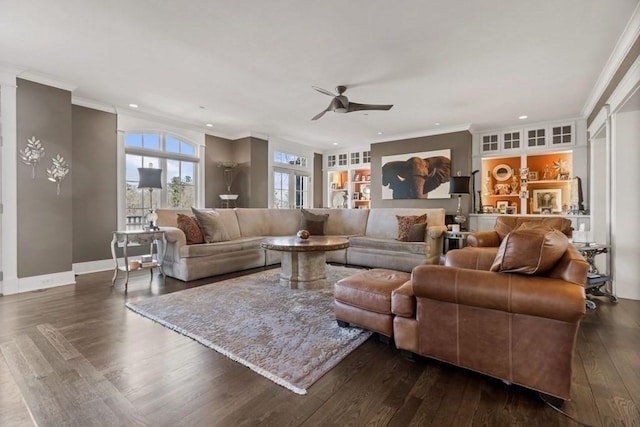 living room with built in shelves, ceiling fan, dark hardwood / wood-style floors, and crown molding