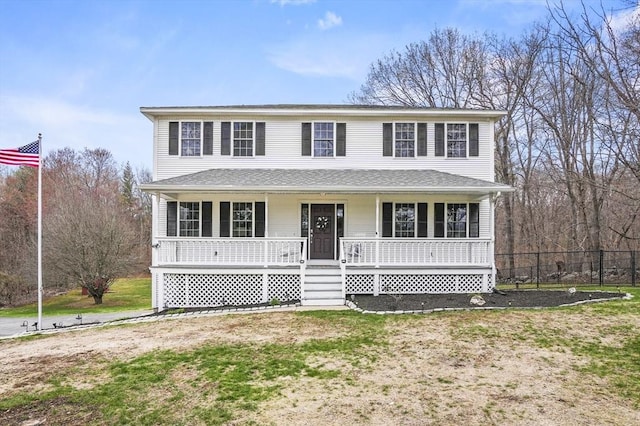 traditional-style house with a porch and fence