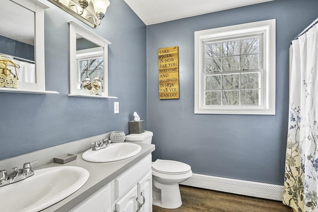 full bath featuring plenty of natural light, a baseboard radiator, and a sink
