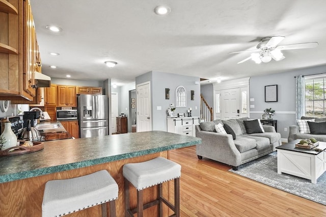 living room with recessed lighting, light wood-style floors, ceiling fan, and stairs