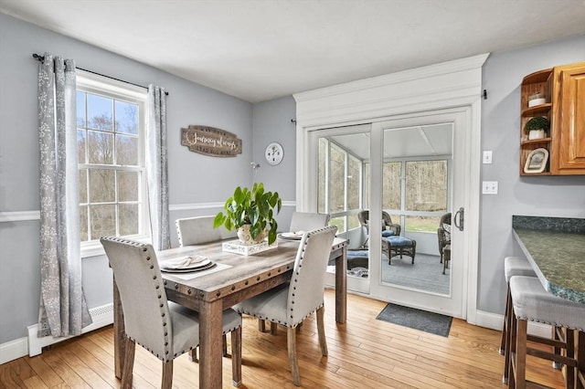 dining room featuring plenty of natural light, light wood-style flooring, and baseboards