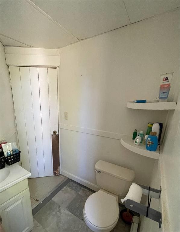 bathroom with vanity, toilet, and baseboards