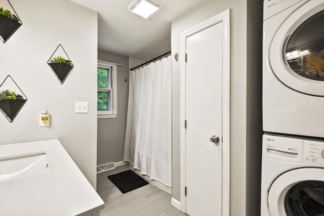 180 Slab Bridge Rd, Freetown, MA 02702 - laundry area featuring stacked washing machine and dryer and baseboards