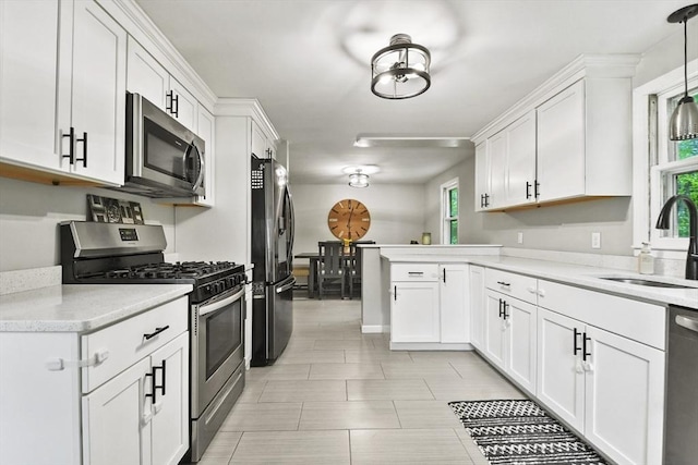 180 Slab Bridge Rd, Freetown, MA 02702 - kitchen with stainless steel appliances, a peninsula, white cabinets, and decorative light fixtures