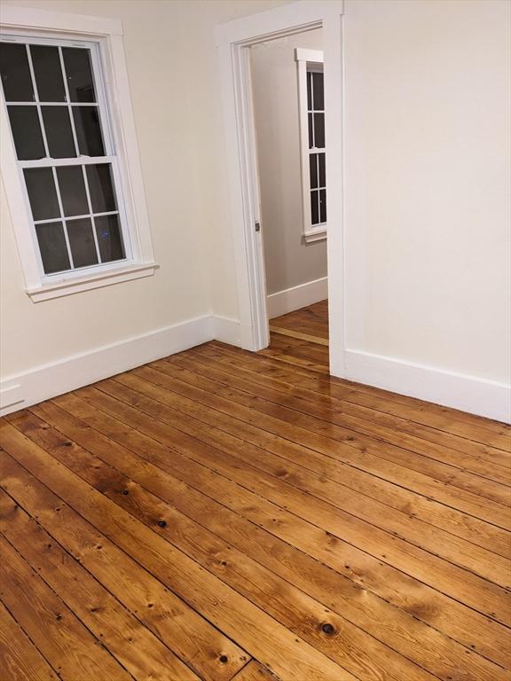 unfurnished room with hardwood / wood-style flooring