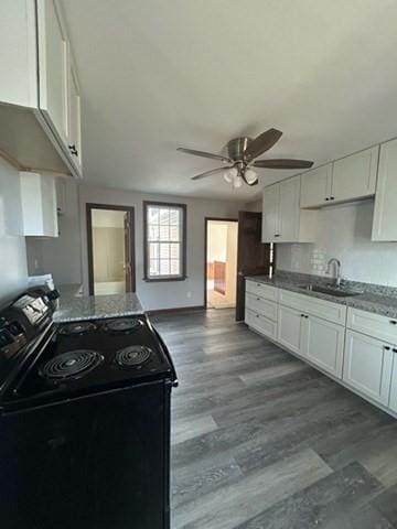 kitchen with ceiling fan, black range with electric stovetop, sink, and white cabinetry