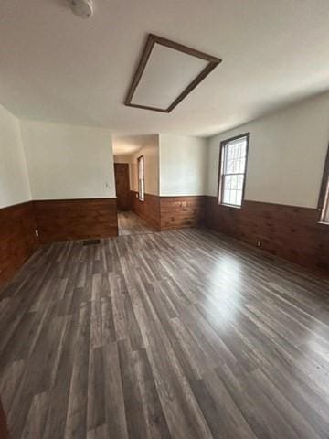 spare room featuring dark wood-type flooring and wooden walls