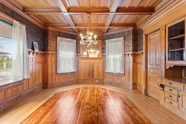 unfurnished dining area featuring wooden walls, a chandelier, and wood ceiling