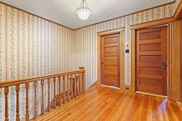 foyer featuring wood-type flooring and wallpapered walls