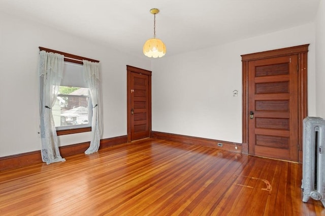 interior space featuring baseboards, radiator, and hardwood / wood-style flooring