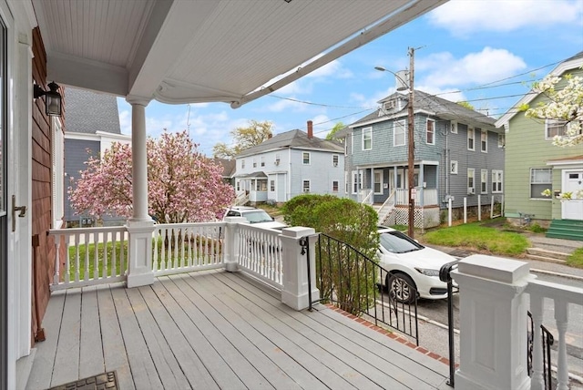 wooden deck featuring a residential view and covered porch