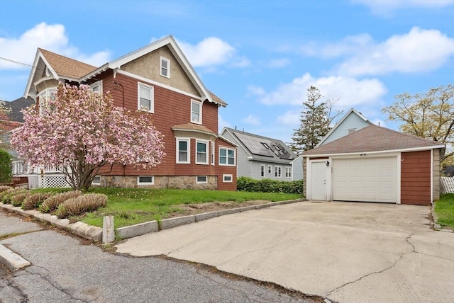 view of side of property with driveway, an outdoor structure, and a garage