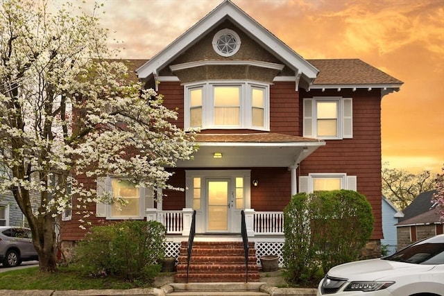 view of front of property with a shingled roof and a porch