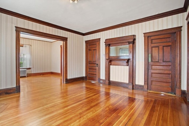unfurnished living room featuring crown molding, baseboards, radiator heating unit, wallpapered walls, and light wood-type flooring