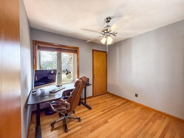 office area featuring baseboards, light wood-type flooring, and ceiling fan