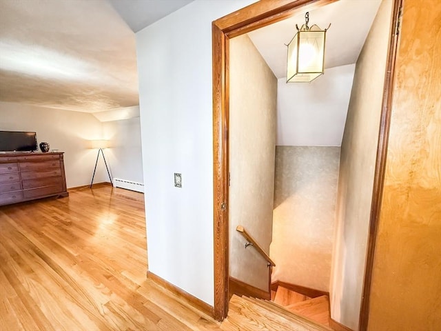 interior space with lofted ceiling, wood finished floors, baseboards, and baseboard heating