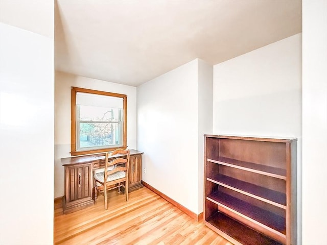 office space with baseboards and light wood-type flooring