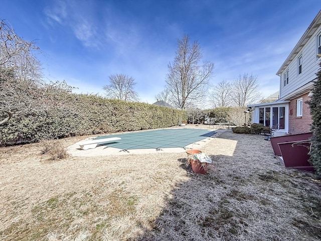 view of swimming pool featuring a patio area, a fenced in pool, and a diving board