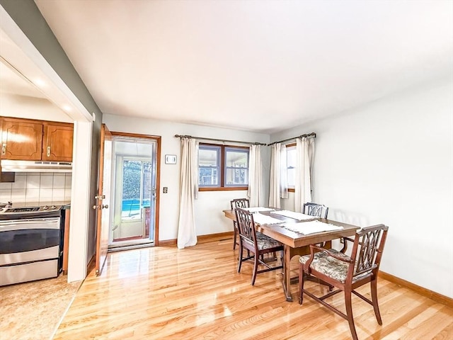 dining space featuring baseboards and light wood-style flooring