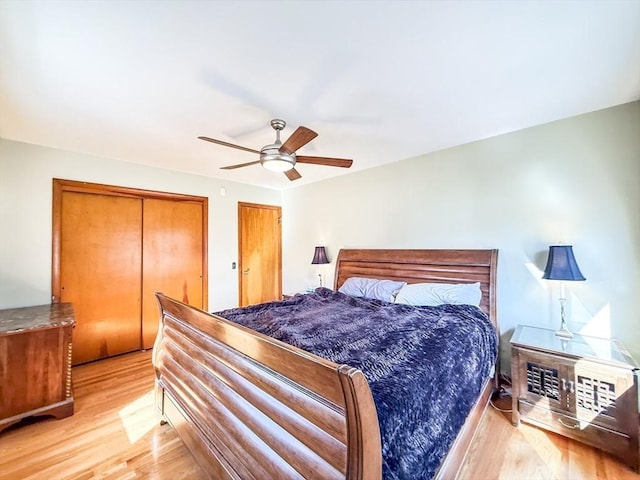 bedroom with light wood-type flooring, multiple closets, and ceiling fan