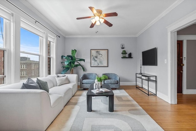 living room with light hardwood / wood-style floors, ceiling fan, and ornamental molding