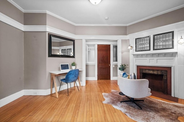 sitting room with a premium fireplace, light hardwood / wood-style floors, and crown molding