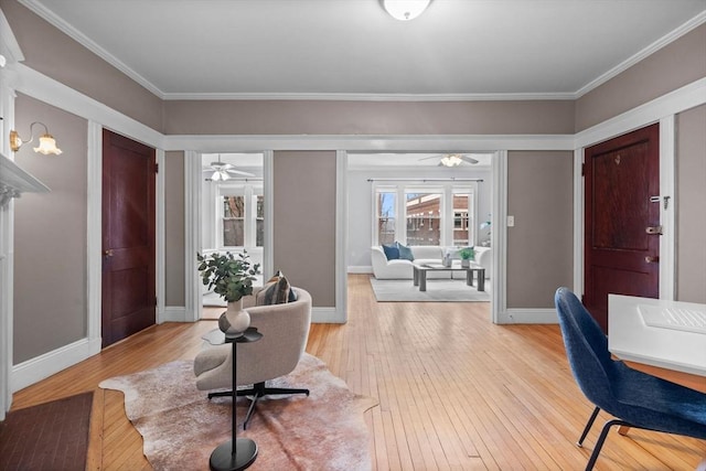 entryway featuring ceiling fan, ornamental molding, and light wood-type flooring