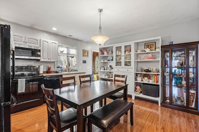 dining area with sink and light hardwood / wood-style floors