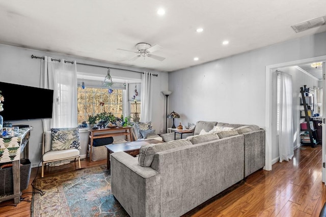 living room with ceiling fan and dark wood-type flooring