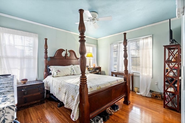 bedroom featuring multiple windows, ceiling fan, and hardwood / wood-style flooring