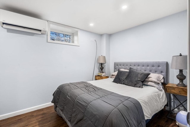 bedroom featuring a wall unit AC and dark wood-type flooring