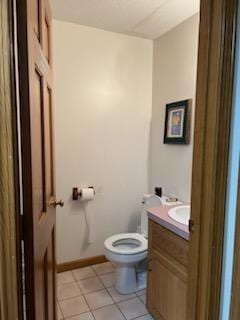 bathroom with tile patterned flooring, vanity, and toilet