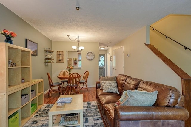 280 Elm St Unit 26, Marlborough, MA 01752 - living room featuring a chandelier, wood finished floors, baseboards, and a textured ceiling