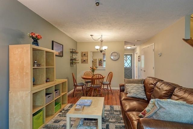 280 Elm St Unit 26, Marlborough, MA 01752 - living area featuring wood finished floors, a chandelier, baseboards, and a textured ceiling