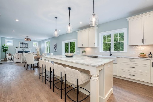 131 Colts Way, Attleboro, MA 02703 - kitchen featuring a sink, recessed lighting, a kitchen island, wood finished floors, and decorative backsplash