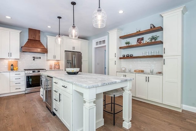 131 Colts Way, Attleboro, MA 02703 - kitchen with stainless steel appliances, custom exhaust hood, beverage cooler, open shelves, and white cabinetry