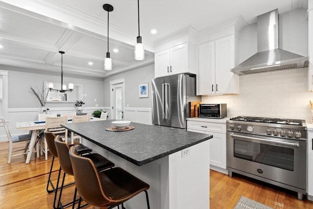 31 Henderson St Unit 1, Arlington, MA 02474 - kitchen featuring wall chimney range hood, appliances with stainless steel finishes, coffered ceiling, white cabinets, and backsplash