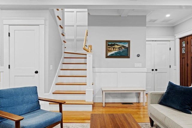 31 Henderson St Unit 1, Arlington, MA 02474 - living area featuring stairway, light wood finished floors, ornamental molding, a decorative wall, and wainscoting