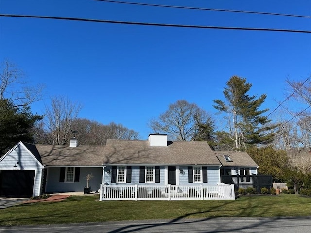 view of front of home with a garage, driveway, a chimney, and a front lawn