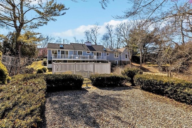 rear view of house with a deck and a chimney