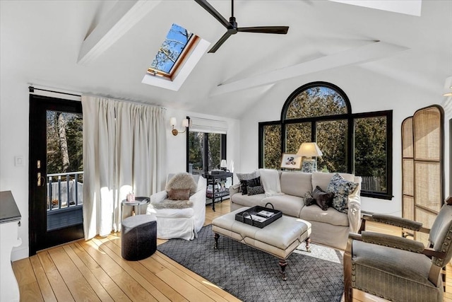 sunroom featuring lofted ceiling with skylight and a ceiling fan